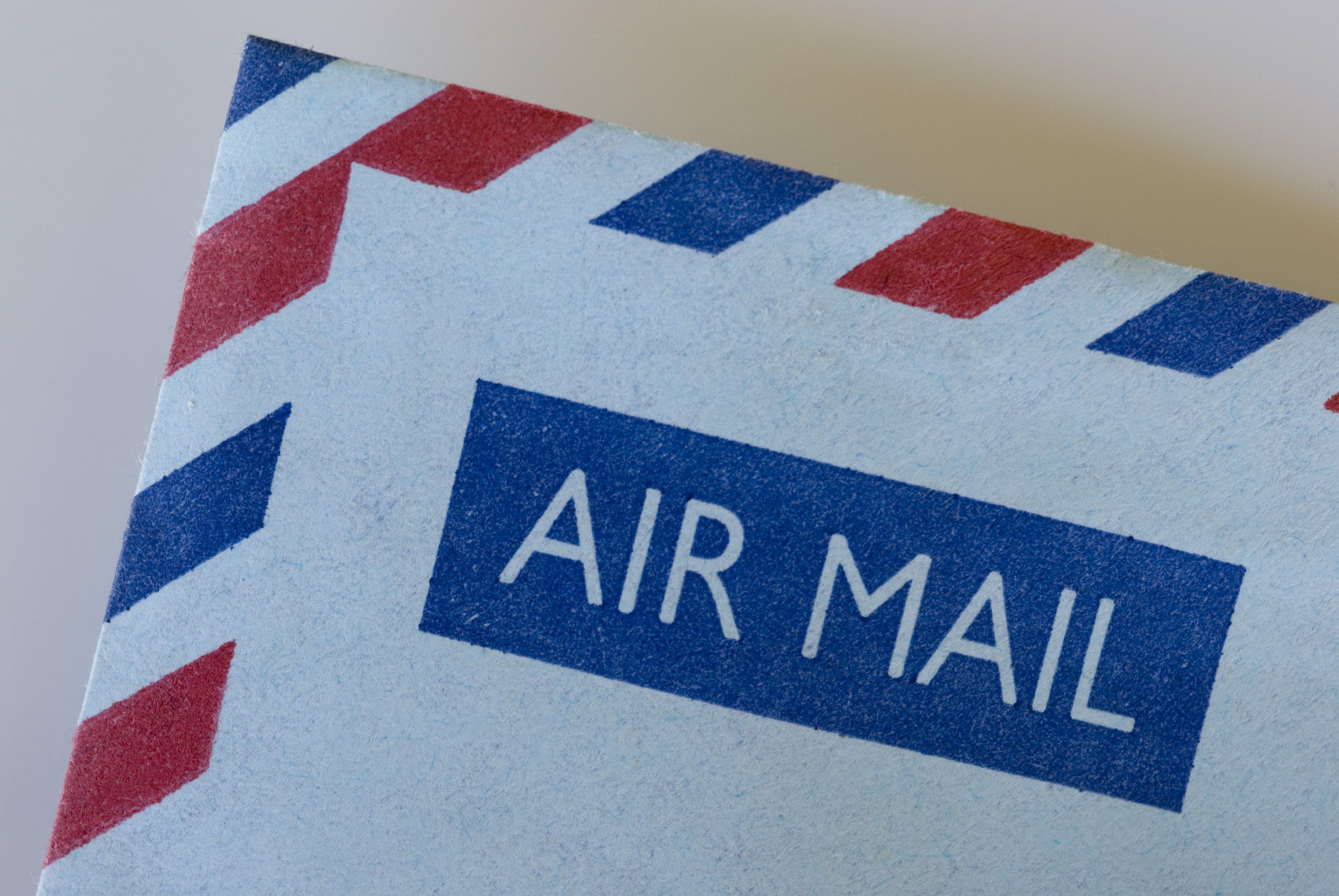 Bild på ett hörn av kuvert som det står "air mail" på. 